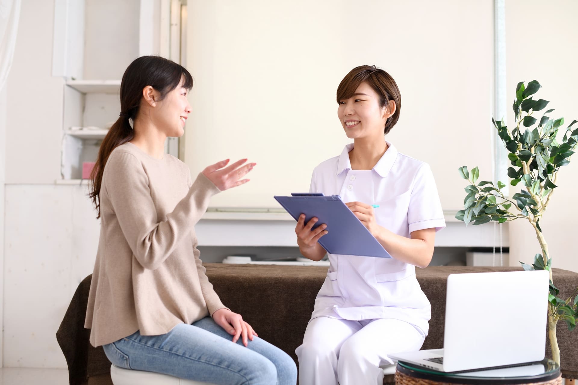 訪問看護師が利用者さんの手を取り、笑顔で寄り添っている様子